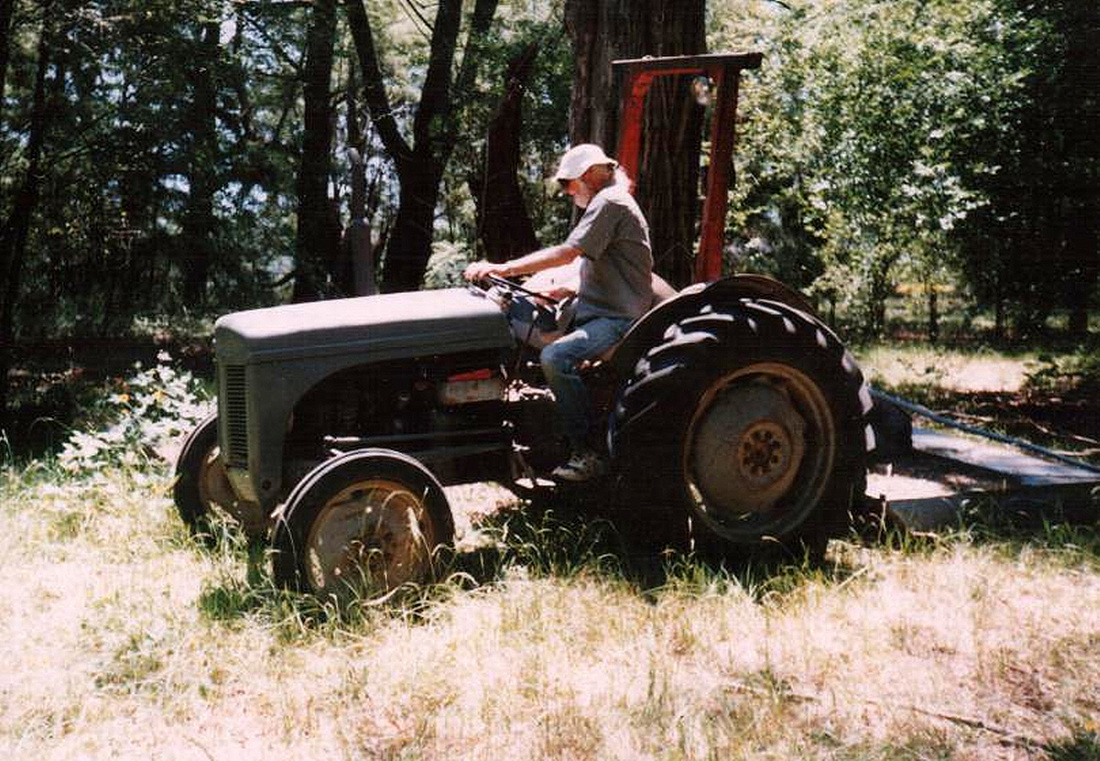 John mowing on tractor at Camp Eureka, 1998.